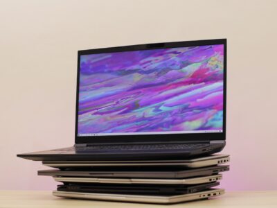 Simple laptop opened up and placed over a stack of normal laptops