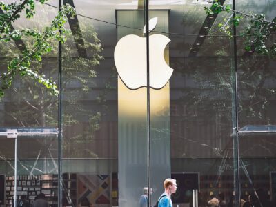 apple logo in street and person walking infront